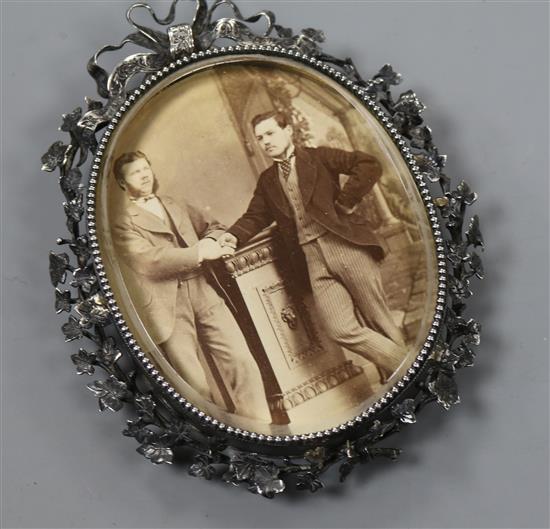 A white metal mounted oval photograph frame, 9.8cm.